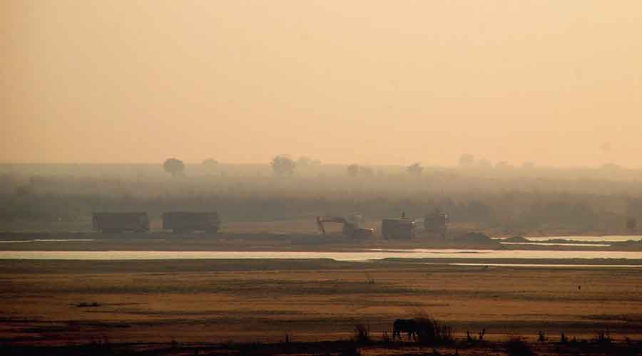 Trucks and earthmovers engaged in illegal sandmining along the causeway in Sone river bed