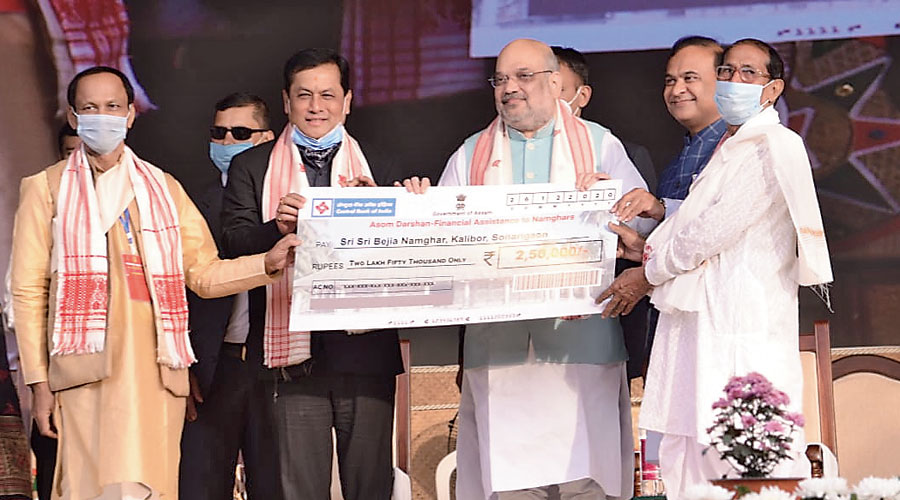 Shah ceremonially distributing financial assistance to naamghars in the state under the Asom Darshan scheme at the event
