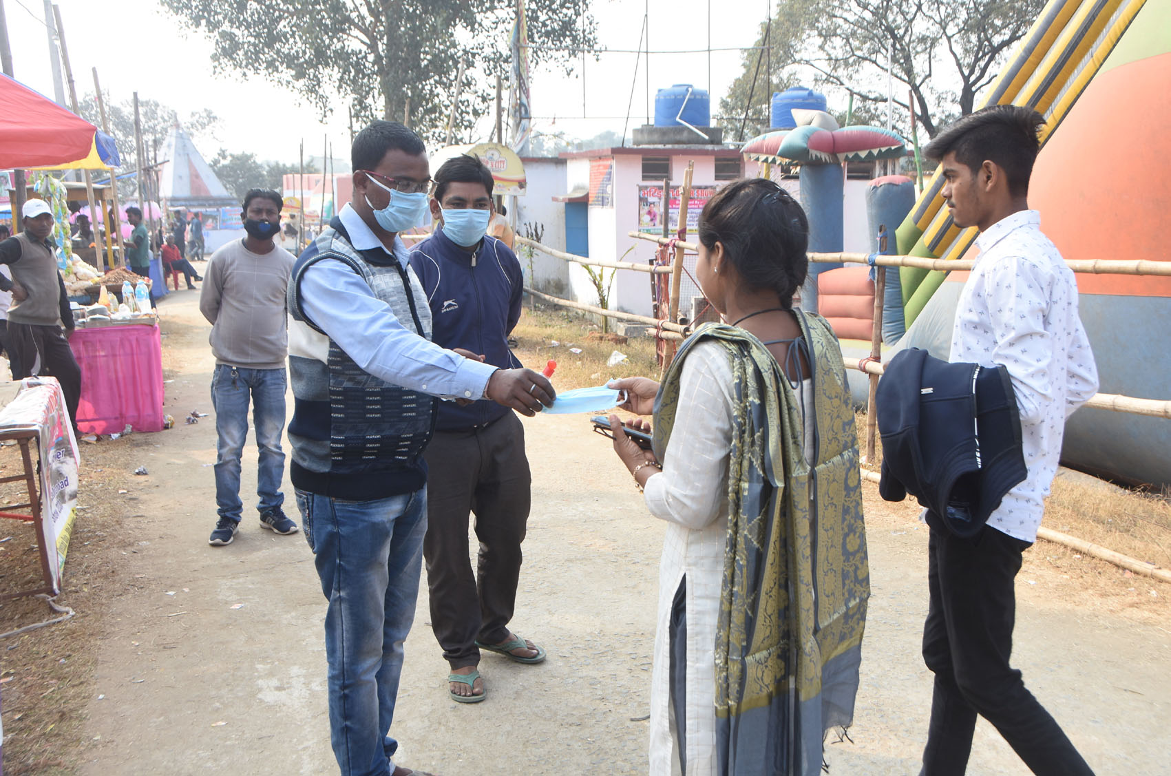 Authorities provide masks to the tourists at the main entrance of Bhatinda Falls in Moonidih, Dhanbad on Thursday to ensure Covid-related norms.