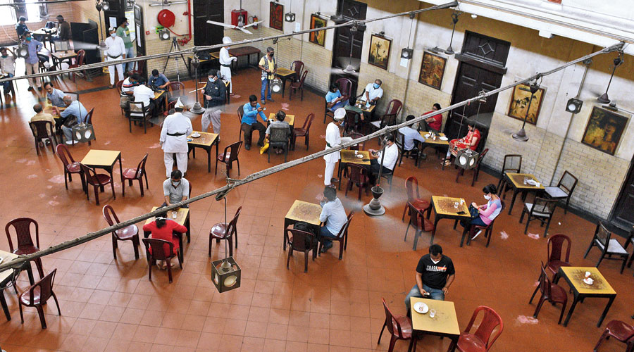 Coffee with care: Customers sit at tables kept at a distance from each other as a precaution against Covid-19 at Coffee House, on College Street, which reopened after the lockdown on Thursday.