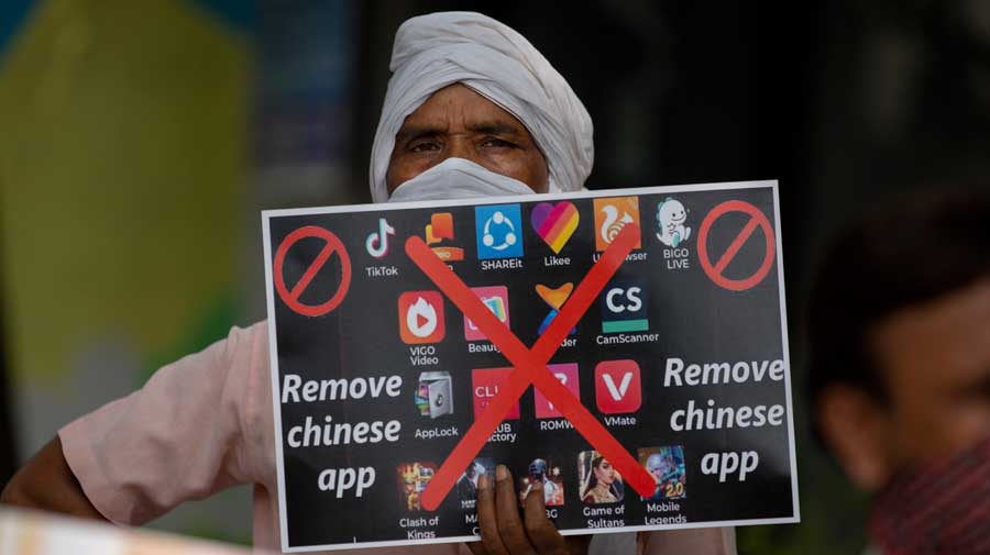 A man holds a placard with logos of Chinese apps during a protest against China in New Delhi on Tuesday.