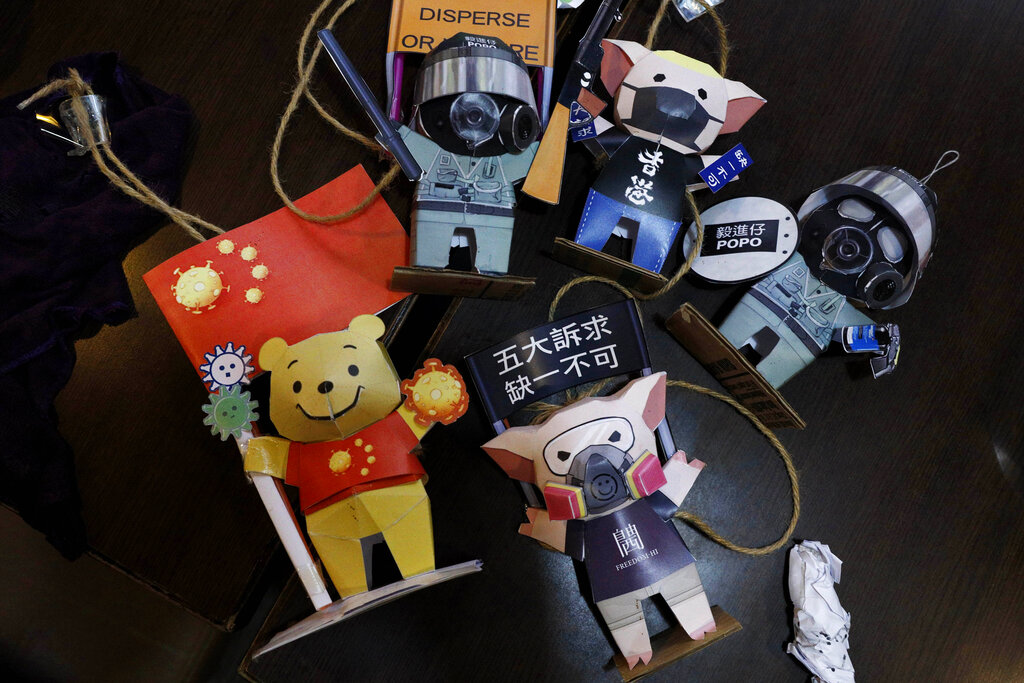 Paper figures of police officers, protesters and Winnie the Pooh, with messages in support of the pro-democracy movement are removed at a restaurant in Hong Kong, Thursday, July 2, 2020. 