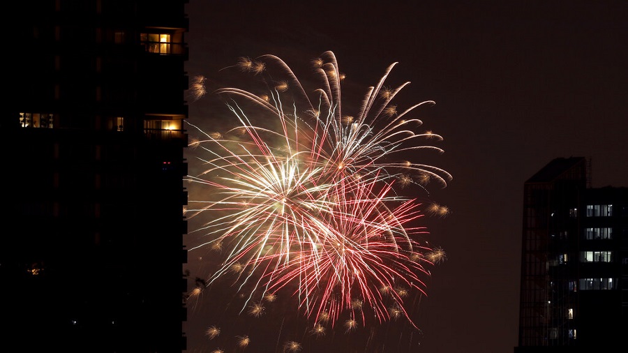 Fourth of July fireworks display lights up the sky beyond an apartment building, Friday, July 3, 2020, in downtown Kansas City, Missouri