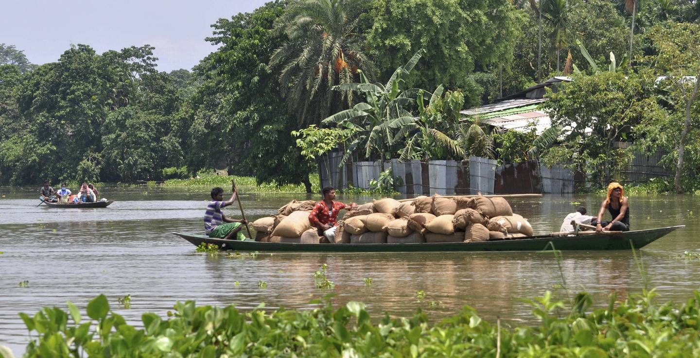 Villagers cross a flooded area on a boat, at Jhargaon in Morigaon district, Tuesday, June 30, 2020
