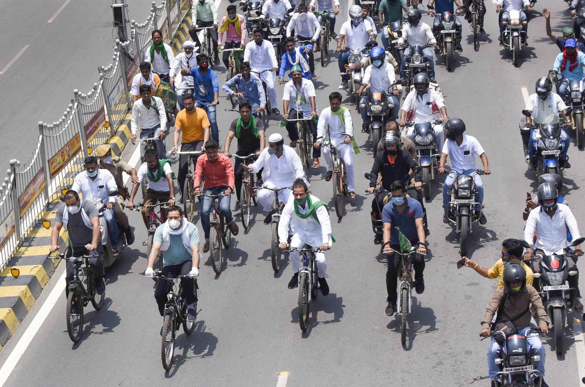 Tejaswi Yadav and Tej Partap Yadav with party workers ride cycles during a protest against fuel price hike, in Patna, Sunday, July 5, 2020