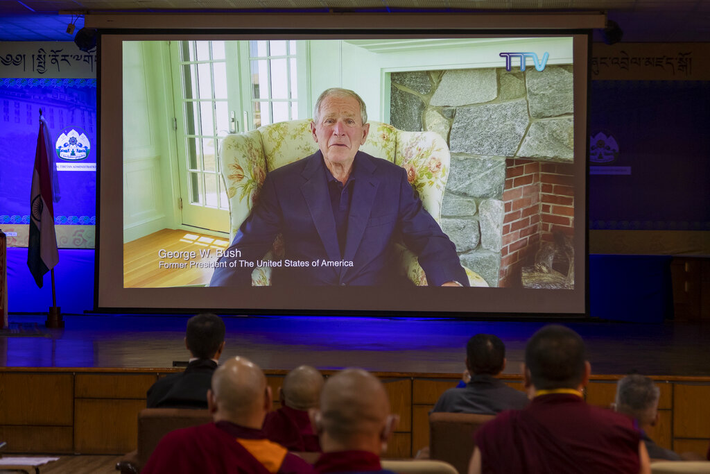 Exile Tibetans watch as former U.S. president George W. Bush delivers a video message to greet Tibetan spiritual leader the Dalai Lama on his the 85th birthday at an official function in Dharmsala, India, Monday, July 6, 2020.