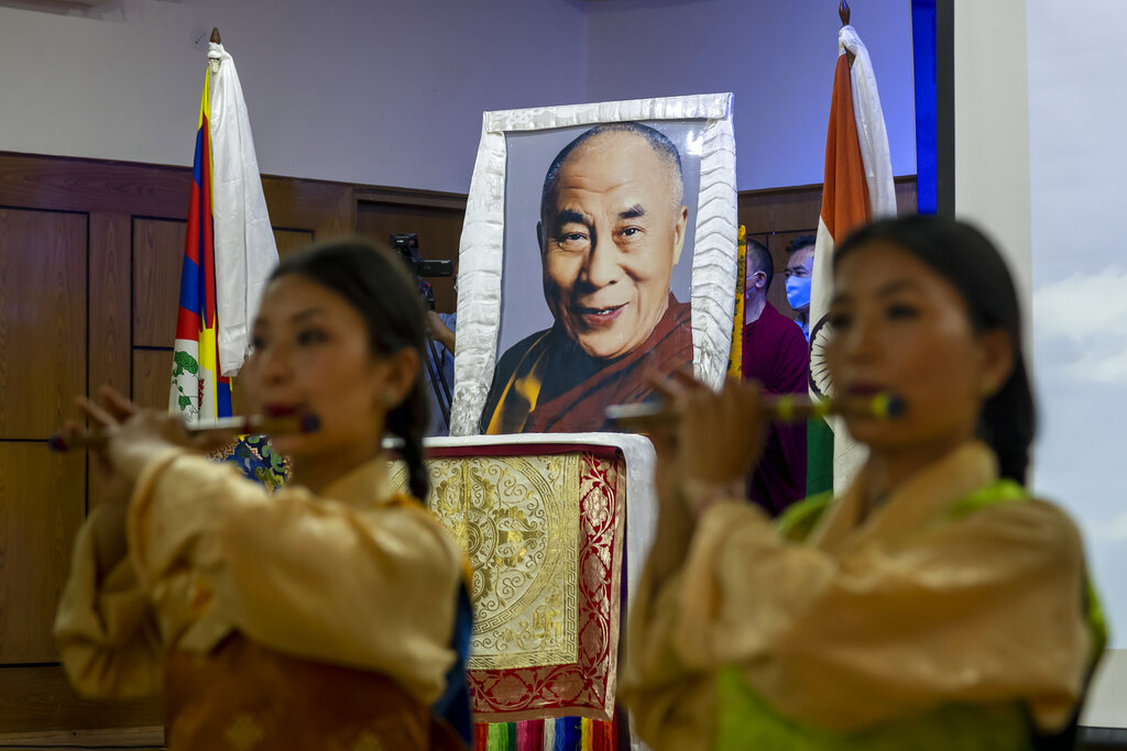 Exile Tibetan artists perform a special song to mark the 85th birthday of their spiritual leader the Dalai Lama whose portrait is seen behind at an official function in Dharmsala, India, Monday, July 6, 2020. 
