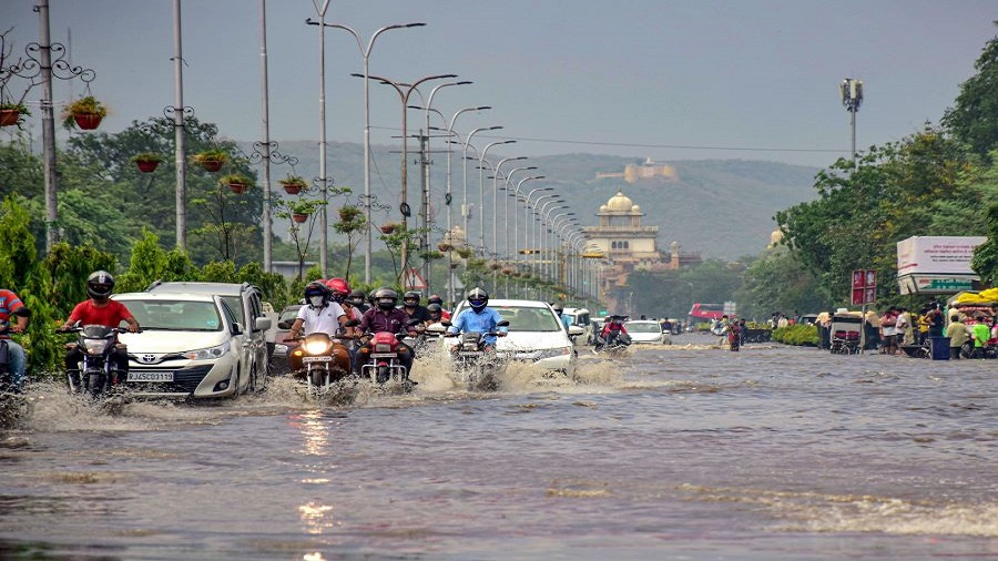 Commuters pass through a waterlogged street following heavy rain, in Jaipur, Tuesday, July 7, 2020.