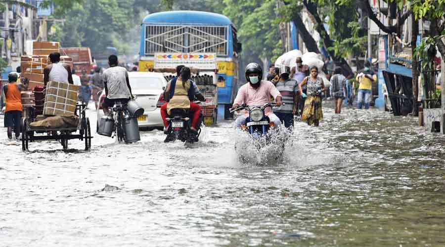 Commuters on waterlogged Bidhan Sarani on Monday afternoon.