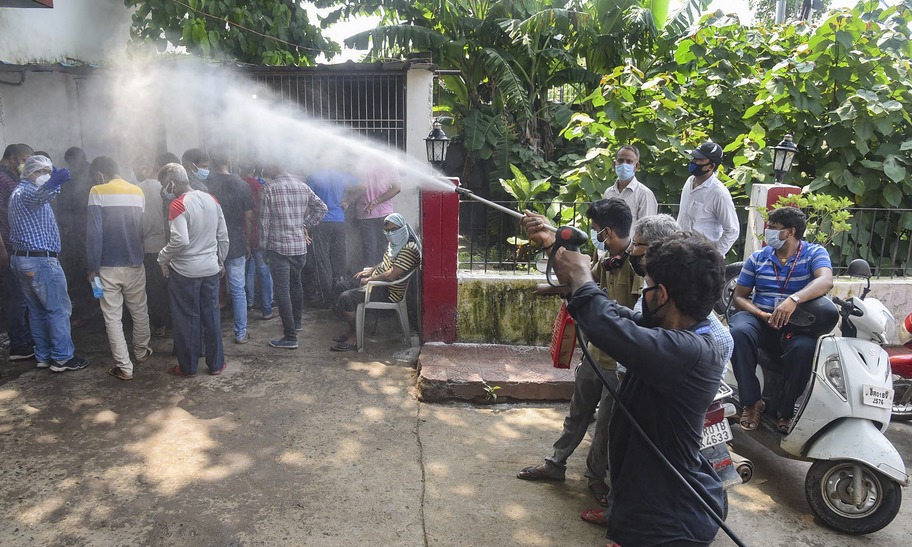 A municipal worker sprays disinfectant in the premises of a Covid-19 test collection centre in Patna, Tuesday, July 14, 2020