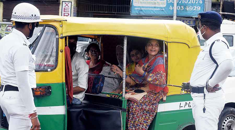 A policeman asks women travelling in an auto to wear masks at Park Circus Seven-Point crossing on Tuesday