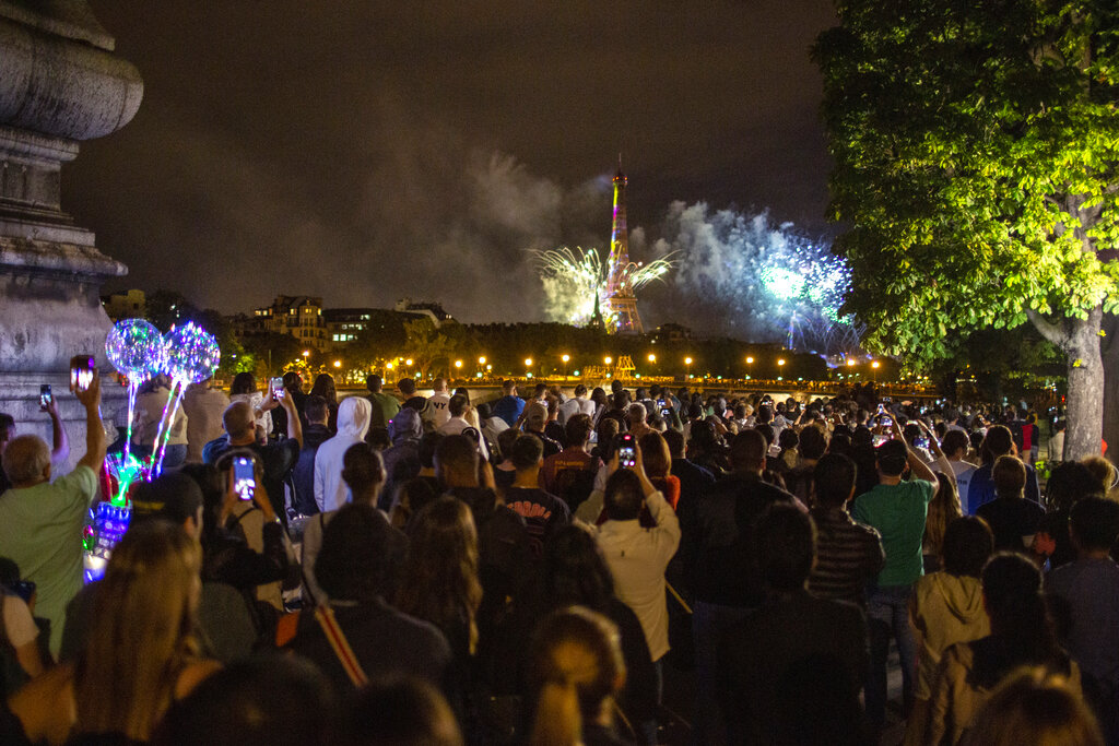 People attend the fireworks display by the Eiffel Tower in Paris during Bastille Day celebrations late Tuesday, July 14, 2020. Bastille Day marks the July 14, 1789, storming of the Bastille prison by angry Paris crowds that helped spark the French Revolution. 