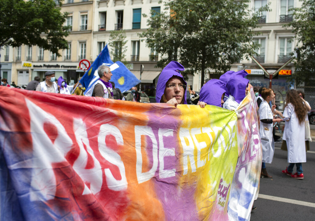 Hospital workers demonstrate on Bastille Day in Paris, Tuesday, July 14, 2020. French hospital workers are protesting to demand better pay and more investment in France's public hospital system, which is considered among the world's best but struggled to handle a flux of virus patients after years of cost cuts. 