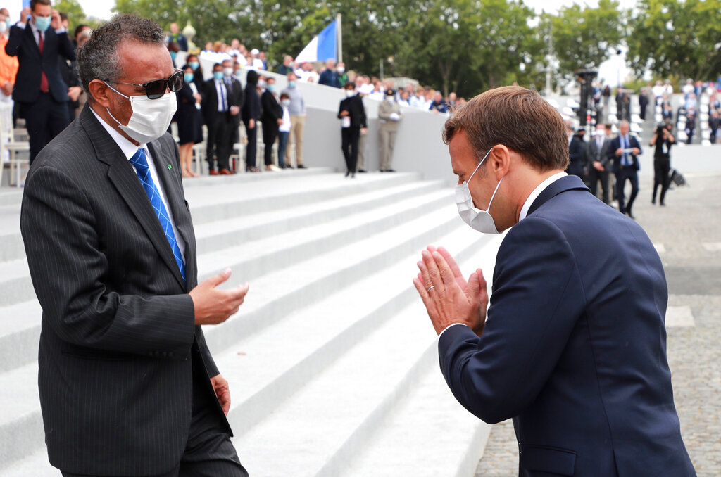 France's President Emmanuel Macron, right, greets Director General of the World Health Organization, Tedros Adhanom Ghebreyesus, at the end of the Bastille Day military parade, Tuesday, July 14, 2020 in Paris.