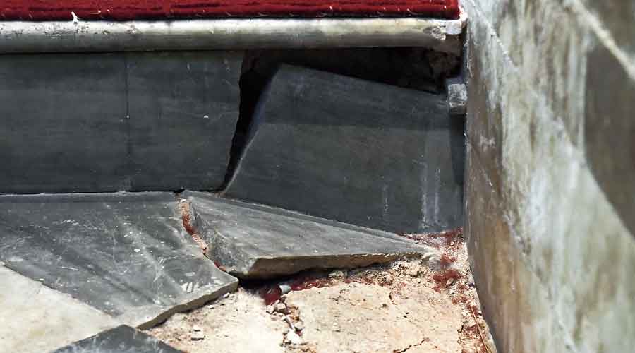 Broken tiles and the damaged floor inside