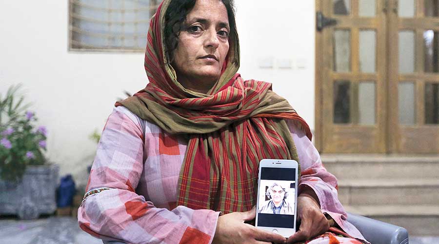 Wife of kidnapped journalist Matiullah Jan shows a picture of her husband on her phone
