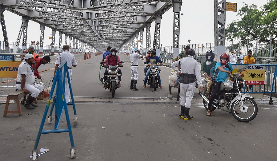 Police personnel stop commuters at Howrah Bridge, during the complete lockdown in the state to curb the spread of coronavirus, in Calcutta, Thursday, July 23, 2020.