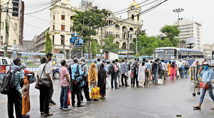 Passengers queue up to board a bus at Esplanade on Monday.