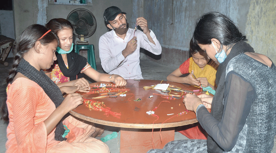 Akhlaque Ahmad (centre) and the special children make rakhis at his home at Katras in Jharia on Wednesday.