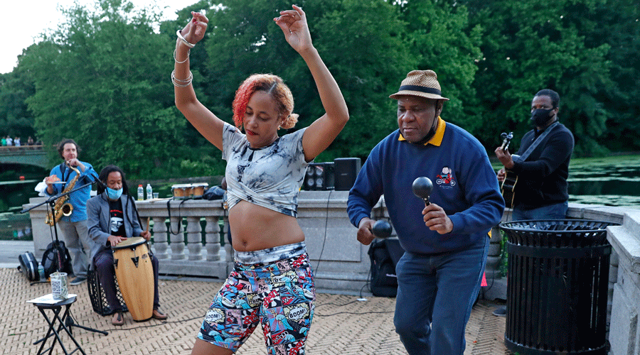 A woman dances to the music during a free concert by Alegba and Friends at Brooklyn's Prospect Park boathouse in New York on June 16, 2020