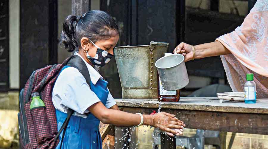 A student washes her hands at Chamata Girls School  at Chamata in Assam’s Nalbari district on Monday after schools re-opened after over seven months