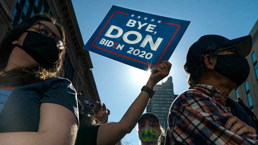 People react after it was announced that Joe Biden was elected the 46th president of the United States on Saturday in Philadelphia. President-elect Biden achieved victory offering a message of healing and unity. He will return to Washington facing a daunting set of crises. 