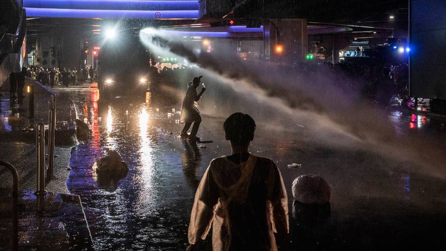 Thai protesters being fired with a water cannon 
