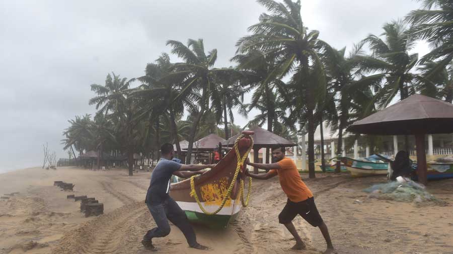 Fishermen move their boats to a safer place near Mamallapuram before the landfall of Cyclone Nivar on Wednesday.