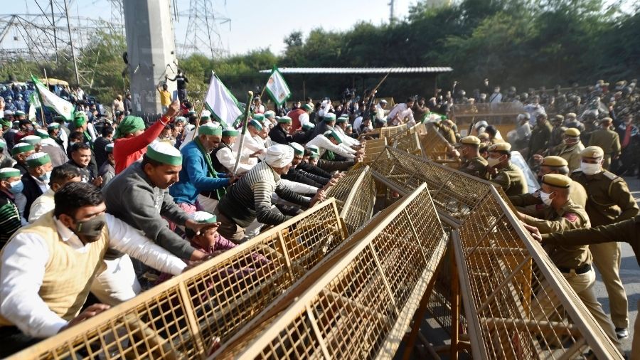 Members of the Bharatiya Kisan Union (BKU) attempt to cross a barricade at the Ghazipur border to enter Delhi.