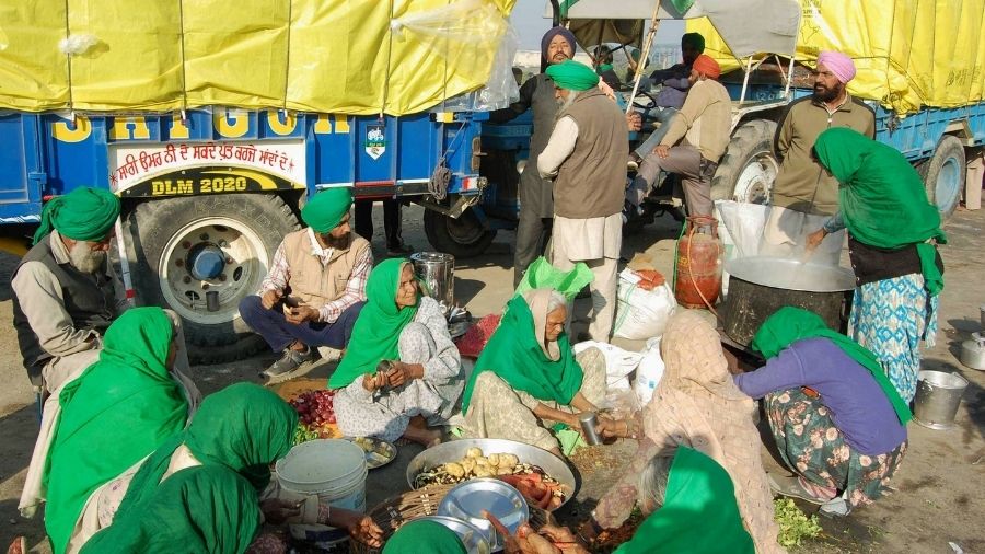 Elderly women, farmers cook for themselves at the Singhu border on Saturday.