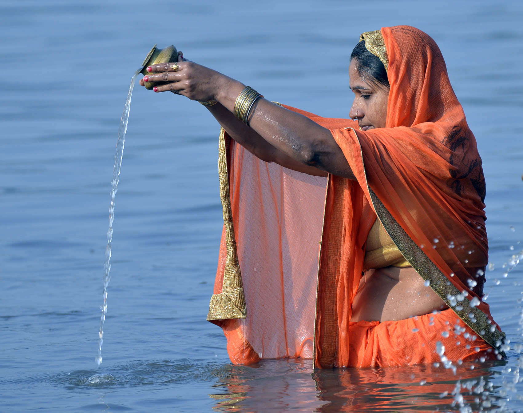 Devotees take a dip and offer prayers in the river Damodar at Mohalbani Ghat in Dhanbad on Monday. 