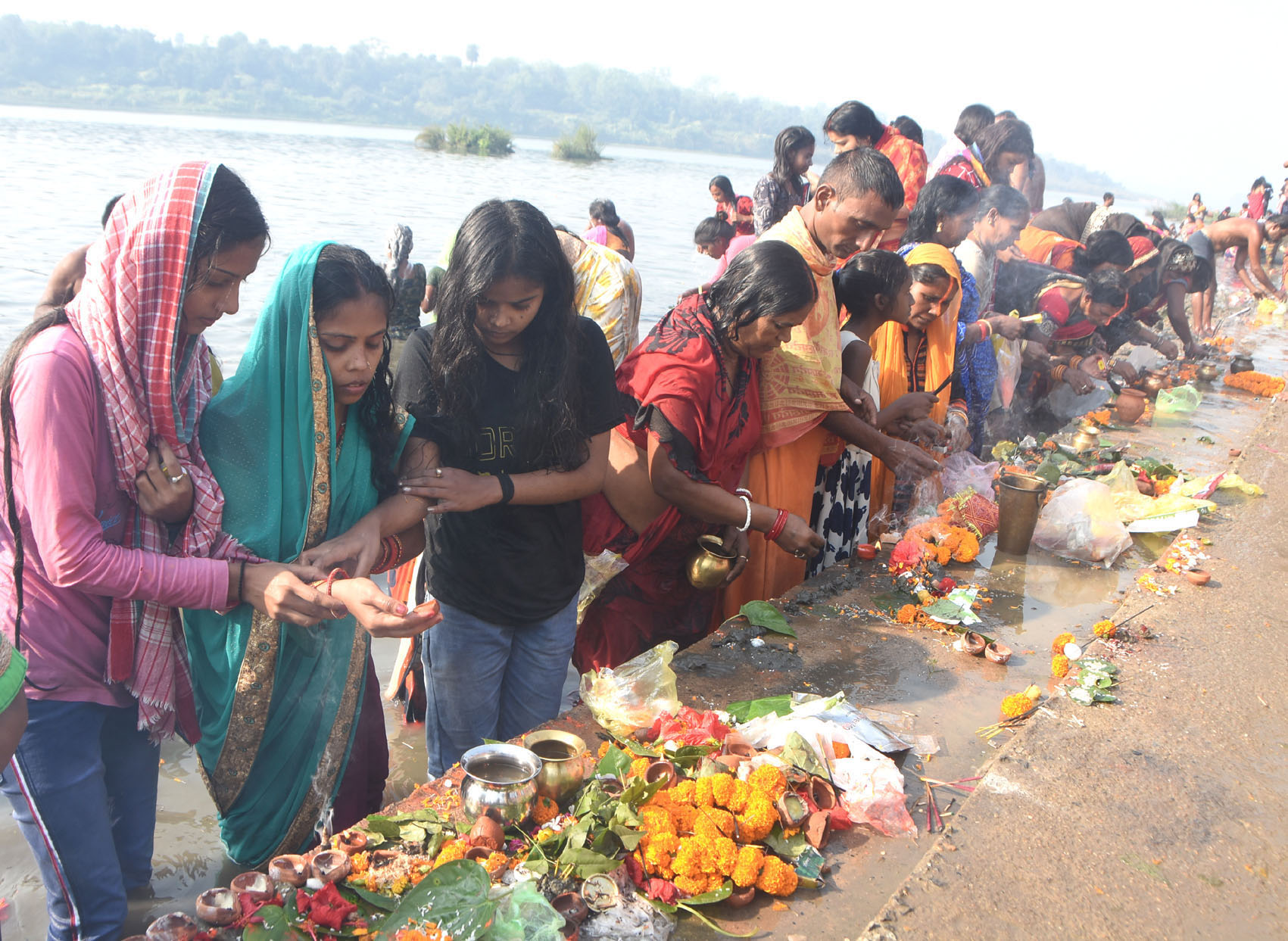 Devotees take a dip and offer prayers in the river Damodar at Mohalbani Ghat in Dhanbad on Monday.