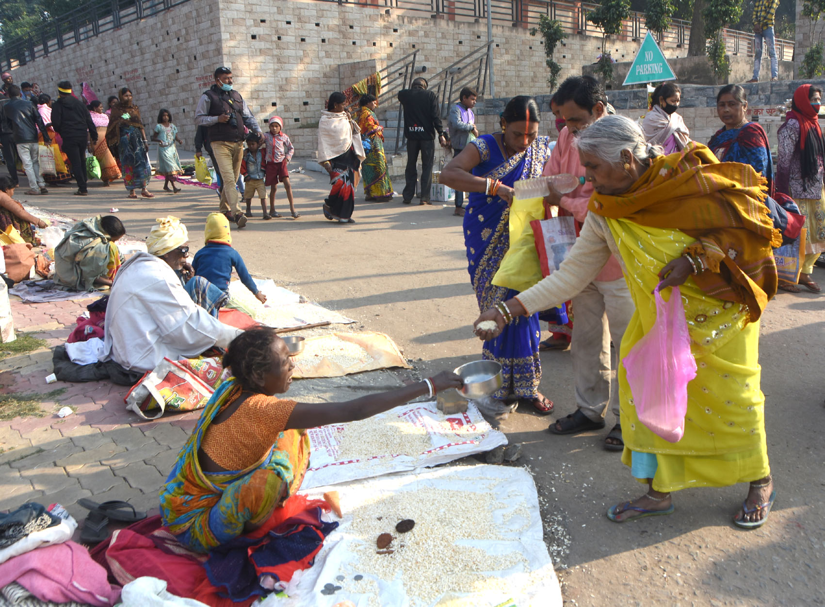Devotees donate food grain, clothes and money to the needy after a holy dip in the river Damodar at Mohalbani Ghat in Dhanbad on Monday. 