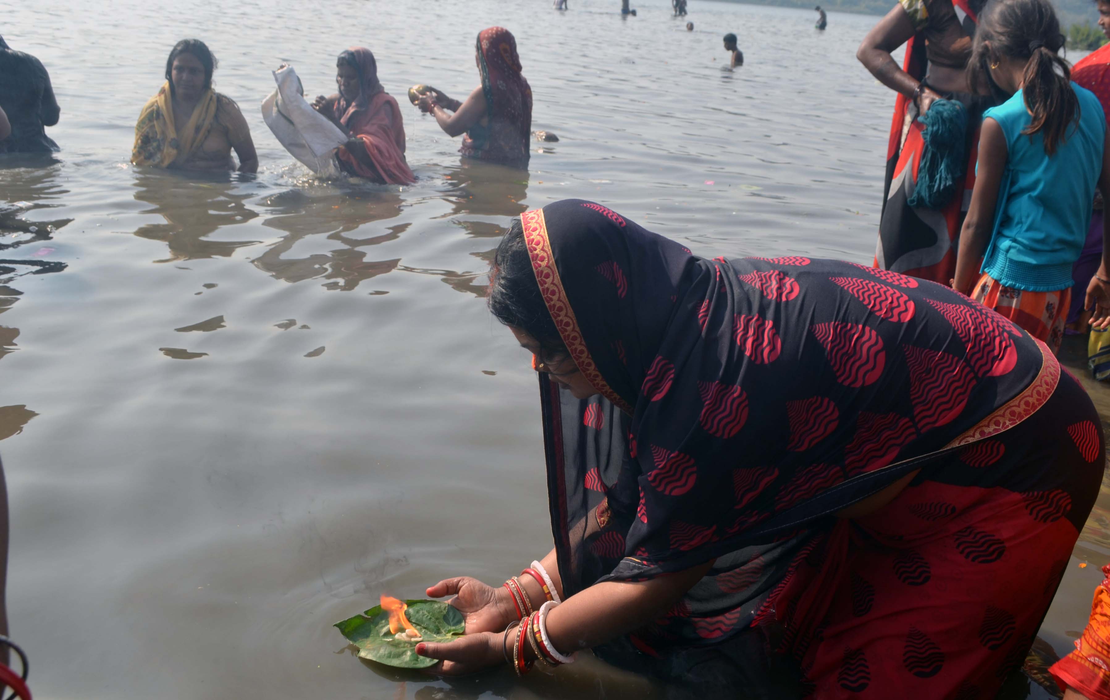 A woman offering prayers to the Sun God after a holy dip in the river Damodar at Dhanbad's Mohalbani ghat on the occasion of Kartik Purnima on Monday. 