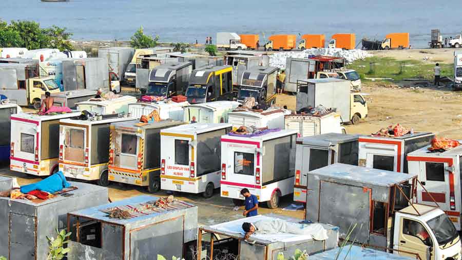 Workers rest atop campaign vehicles on the banks of the Ganga in Patna on Wednesday