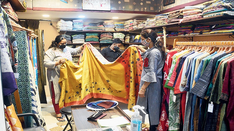 Customers check out saris at Face and (right) Vermilion, both in City Centre. 