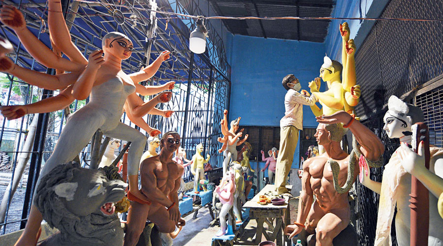 Kesto Das works on a Durga idol at the Khidirpur Sarbojanin club, which has offered him space. 