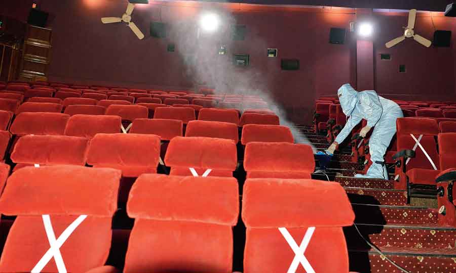 A worker sanitises a cinema hall in New Delhi on Tuesday, as multiplexes prepare to reopen from October 15