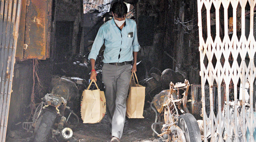 Another resident of Moon House at 21 Ganesh Chandra Avenue come out of the building with whatever could be salvaged on Sunday.