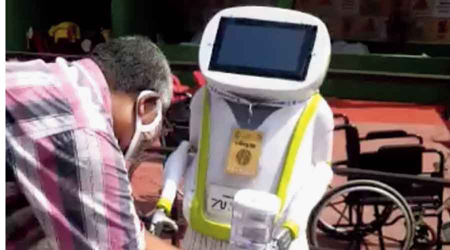 A robot that dispenses sanitiser and masks if a visitor places his or her hand in front of it at Thakurpukur SB Park
