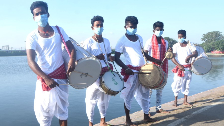 Dhakis during the bath of kola bou at Loco Tank in Dhanbad on Friday. 