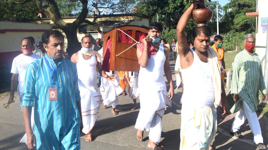 After the bath and worship of kola bou, devotees carry navapatrika and kalas to the puja mandap in Dhanbad on Friday. 