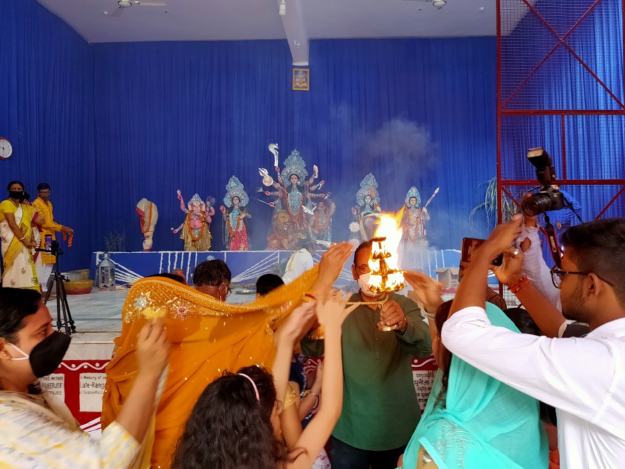 Devotees seek blessings from the Arti at Deshpriya Club. 