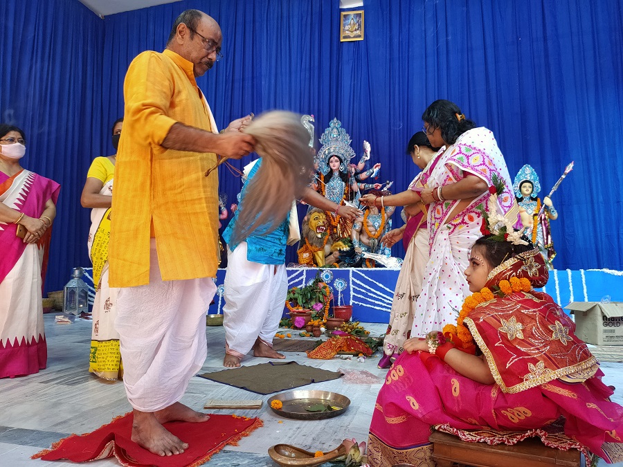 The priest performs a ritual of Kumari Puja on the occasion of Maha Astami at Deshpriya Club.