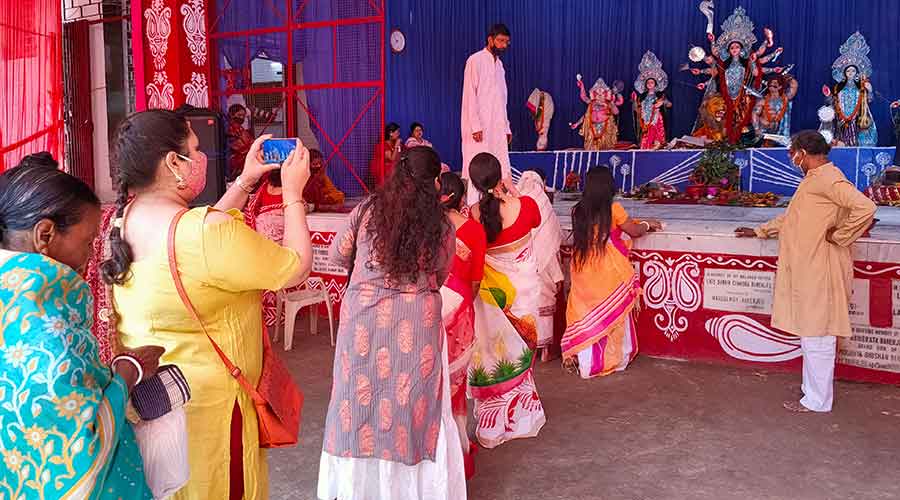 Devotees stand in a queue to perform sindur khela at Deshpriya Club Tharpakna in Ranchi on Monday.