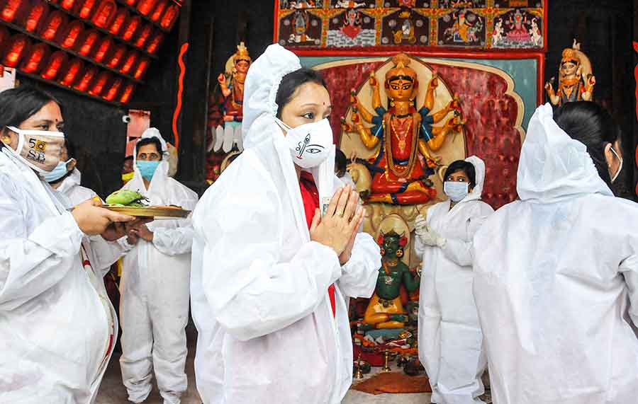 Women devotees wearing PPE kits perform rituals during Bijoya Dashami celebrations at a community Durga Puja pandal, in Calcutta, Monday, Oct. 26, 2020.