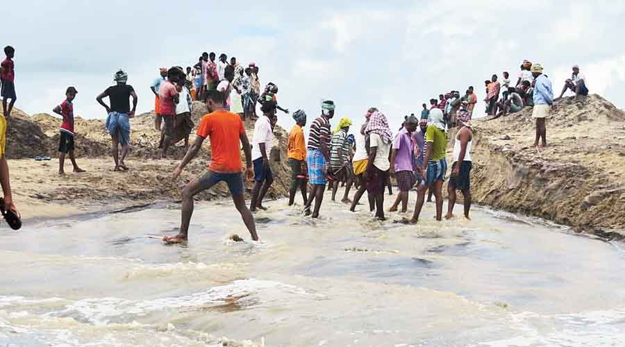 Migrant labourers help villagers dig the new mouth of the Rushikulya river in Odisha’s Ganjam district