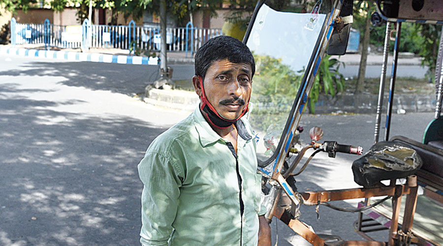 Nitai Bagh, a rickshaw-puller in Salt Lake, was puffing a bidi with his mask hanging around his neck.