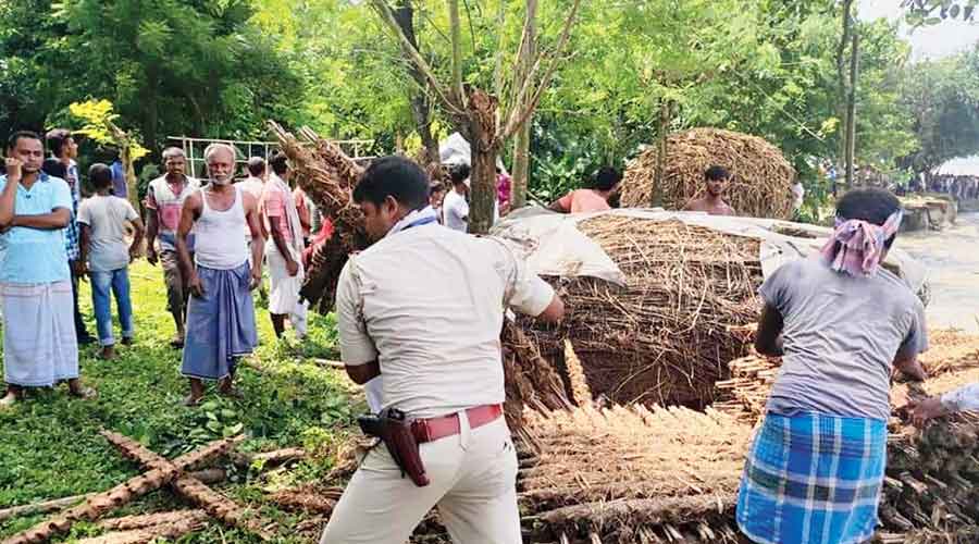 A policeman helps affected residents remove household items