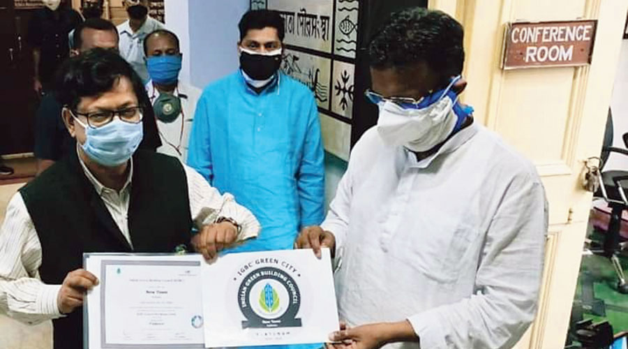 Hidco chairman Debashis Sen presents the certificate to urban development minister and Calcutta mayor Firhad Hakim at the Calcutta Municipal Corporation